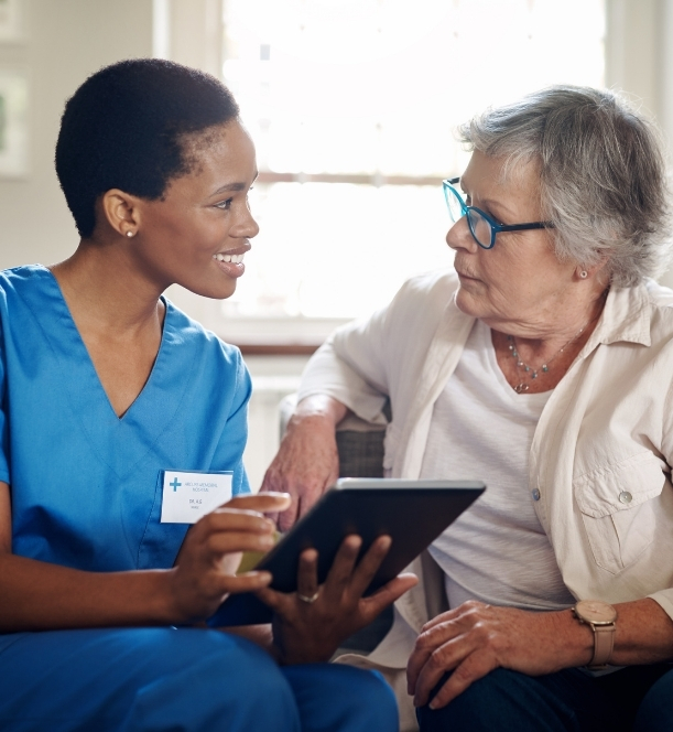 Registered nurse reviewing a personalized care plan with a senior and his daughter at home
